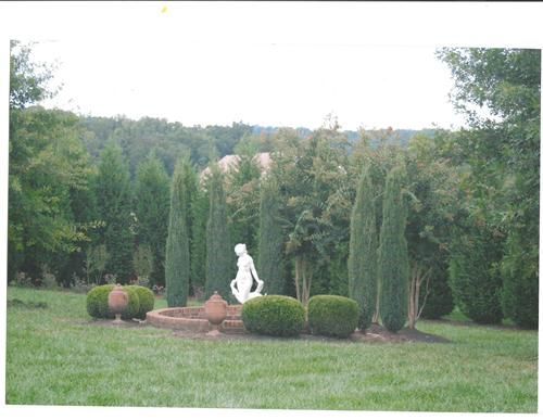 A statue of a woman is in the middle of a garden