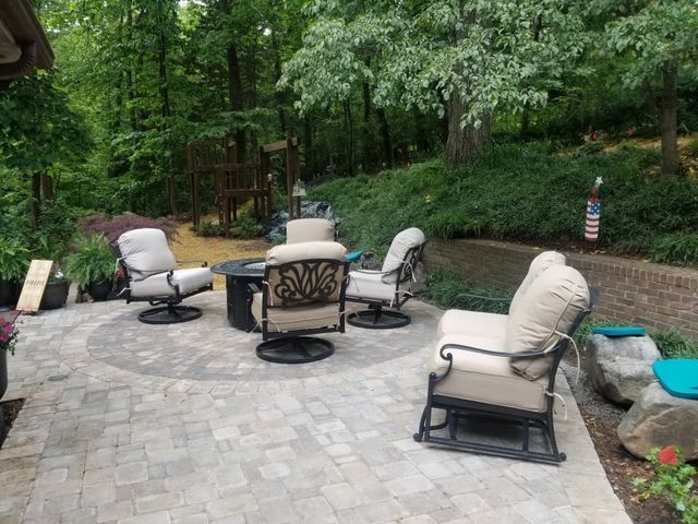 A patio with a table and chairs in the middle of a forest.