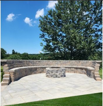 A stone wall with a fire pit in the middle of it