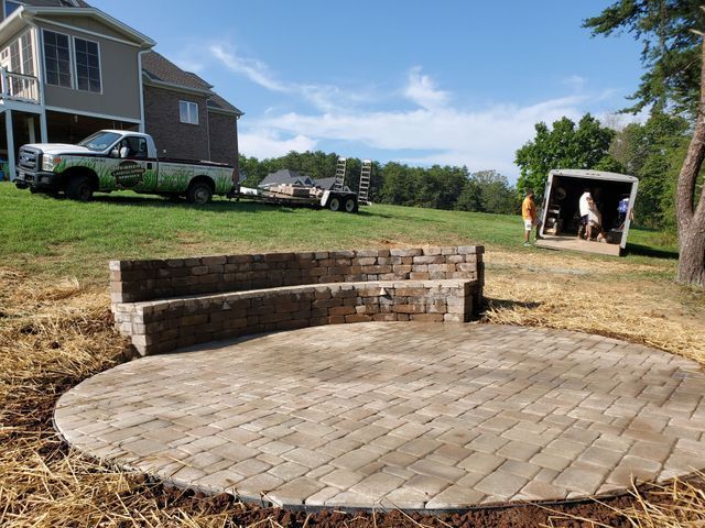 A truck is parked in the grass in front of a house