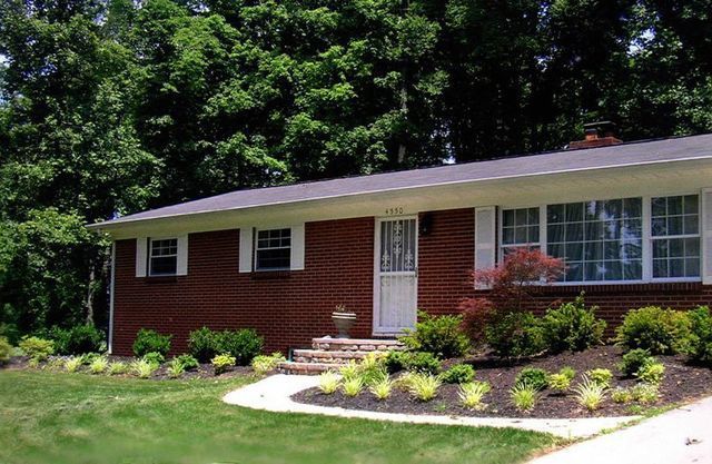 A brick house with a white door and shutters