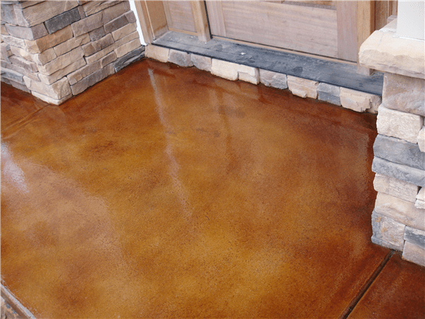 Brown stained concrete porch with stone accents.