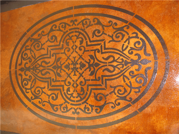 Oval stencil design on a faux-finished surface; dark pattern on an orange background.