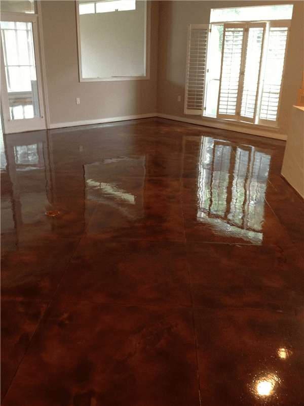 Shiny, brown metallic epoxy floor reflecting light from windows in a room.