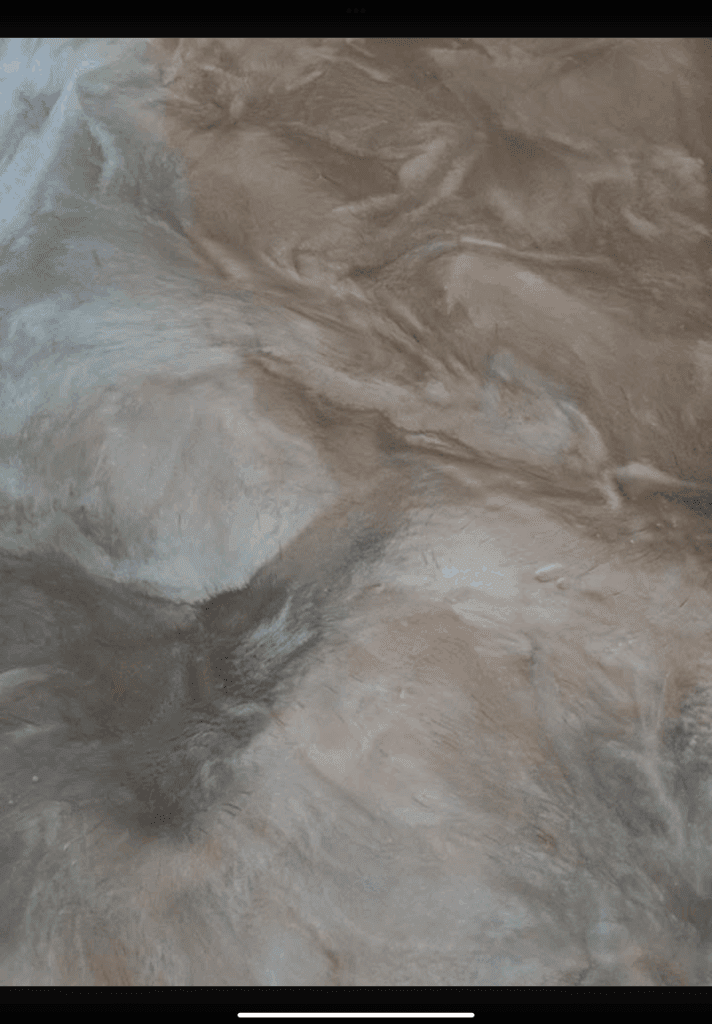 Swirled metallic epoxy flooring in shades of gray and white, resembling flowing liquid.