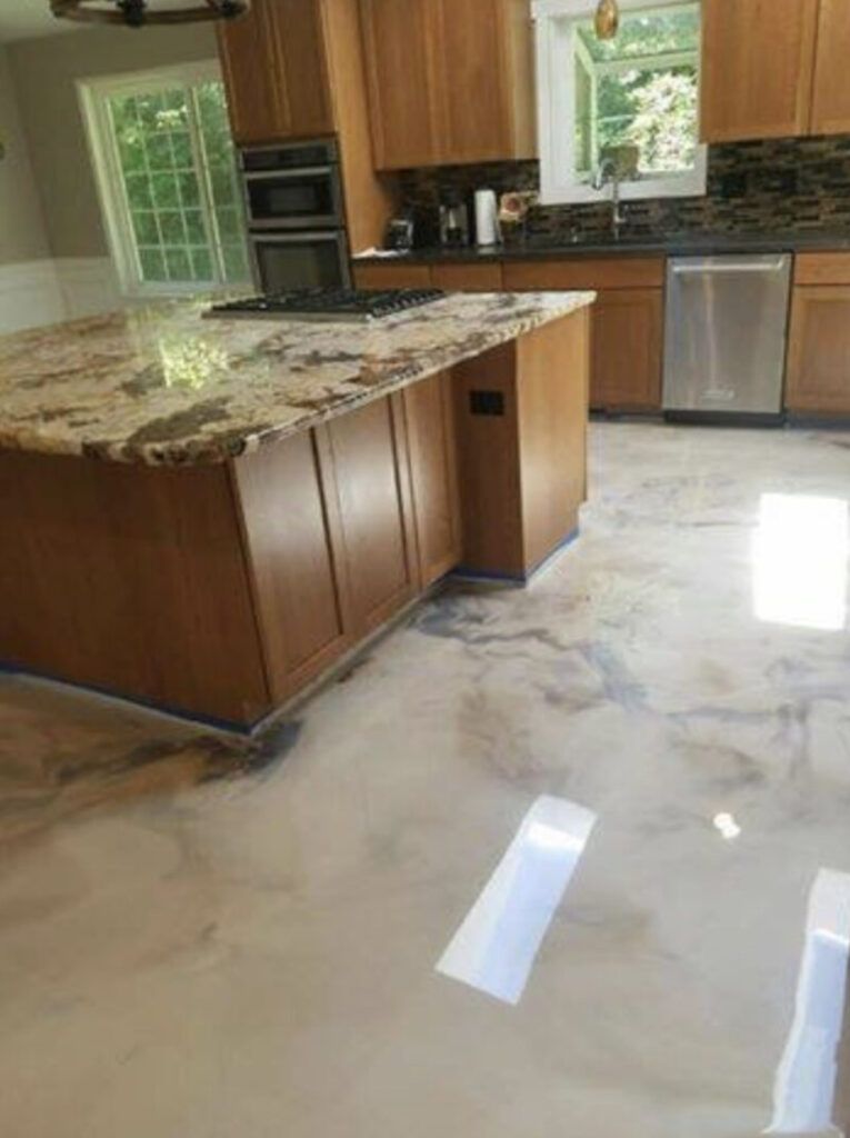 Kitchen with a brown island, granite countertop, and light-colored, patterned floor. Cabinetry is also brown.
