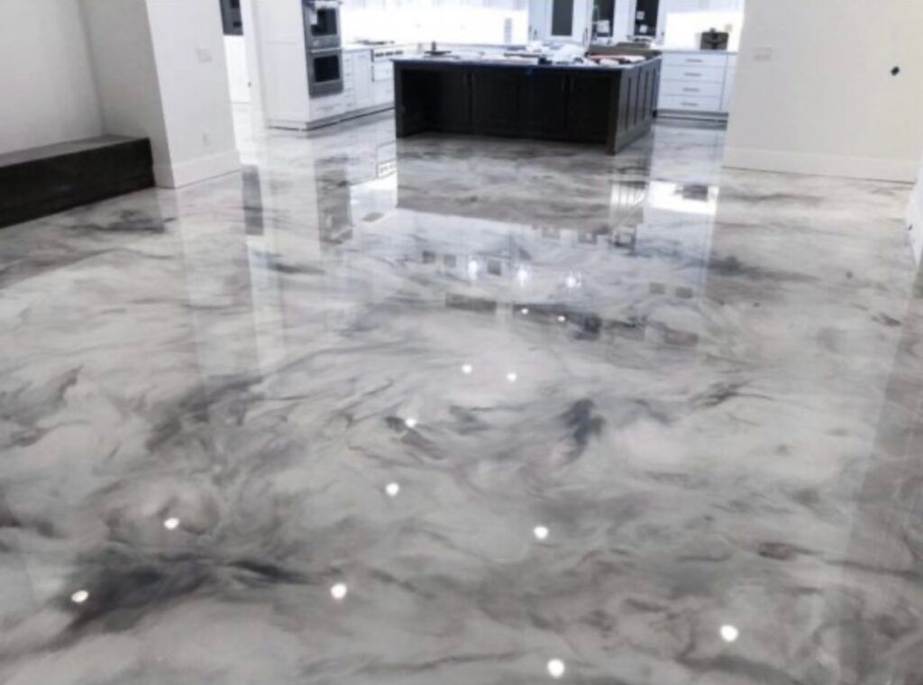 Glossy gray and white epoxy flooring in a modern kitchen with island and white cabinets.