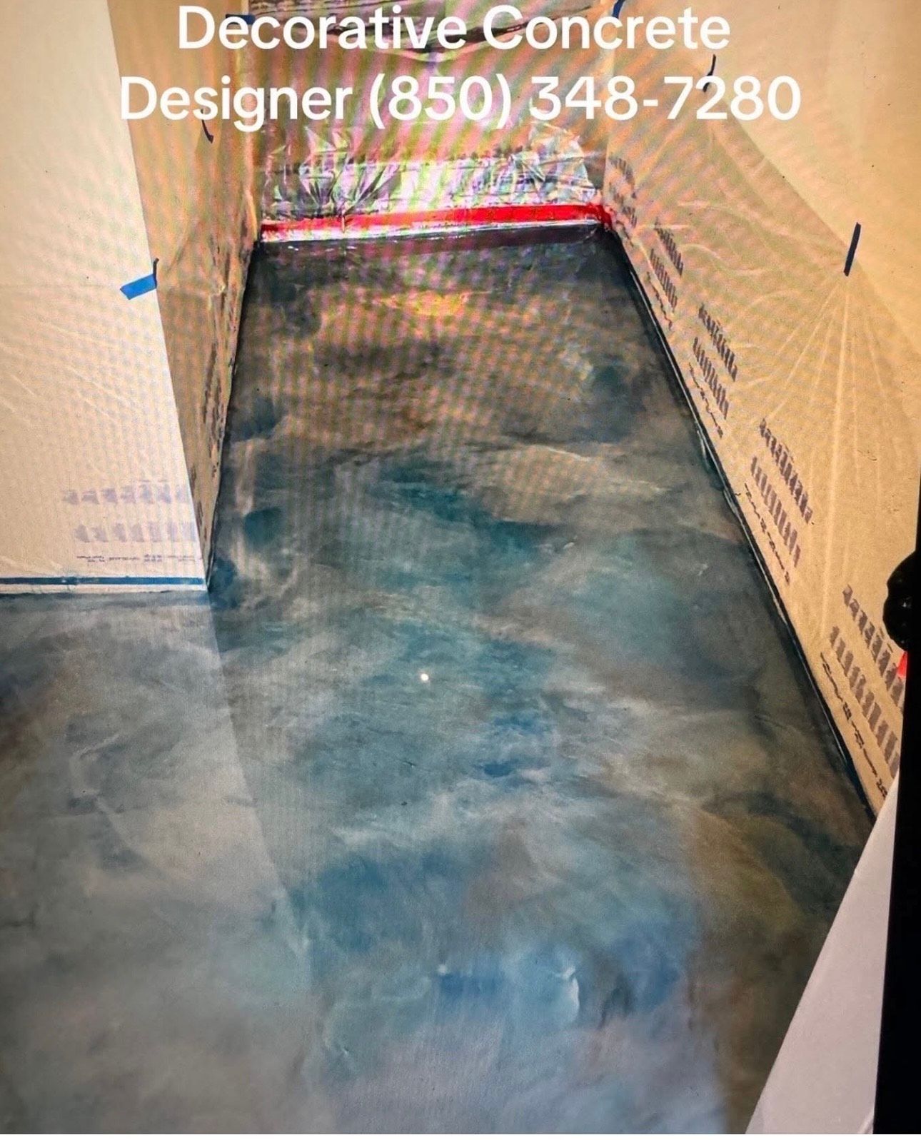 Metallic epoxy concrete floor, blue-green hues, in a room with light beige walls.