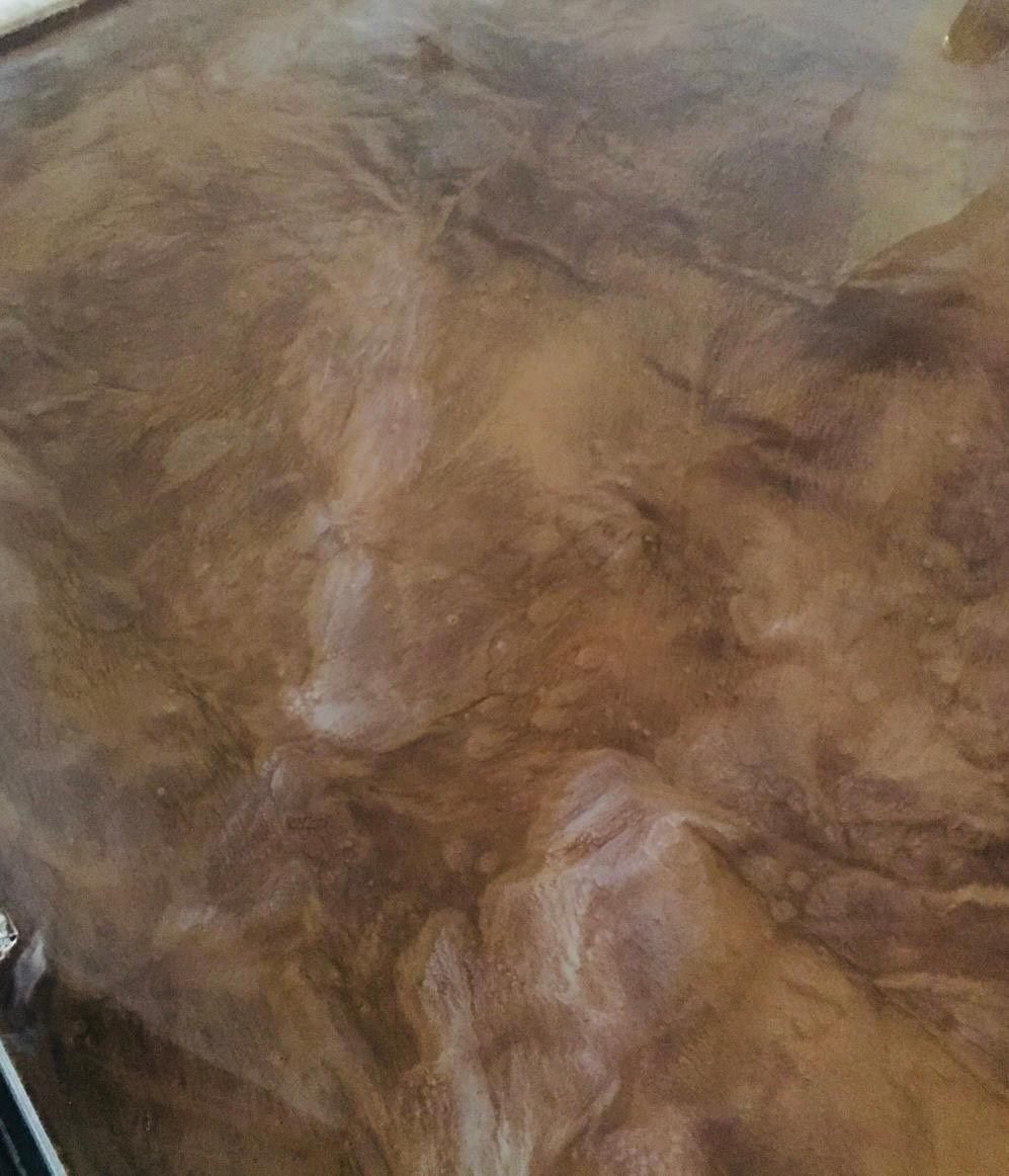 Brown marbled surface with light and dark swirls.