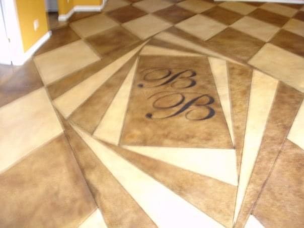 Decorative concrete floor with a swirling geometric pattern in shades of brown and beige, and initials BB.
