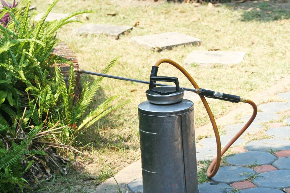 A Garden Sprayer On A Dark Cylinder Spraying Plants — Brazel's Pest Control in Nambucca, NSW