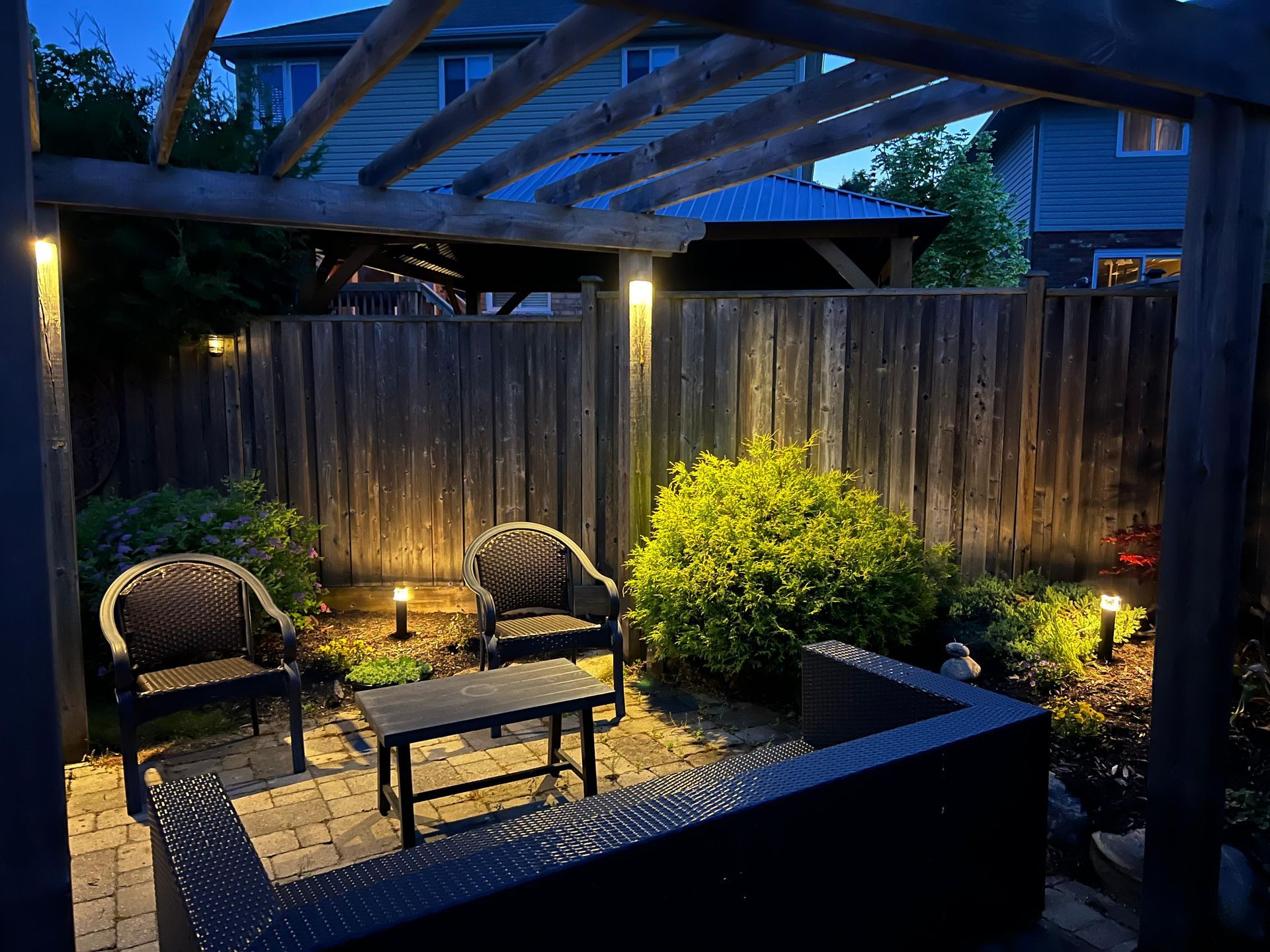 Cozy backyard seating area under pergola with ambient patio lighting