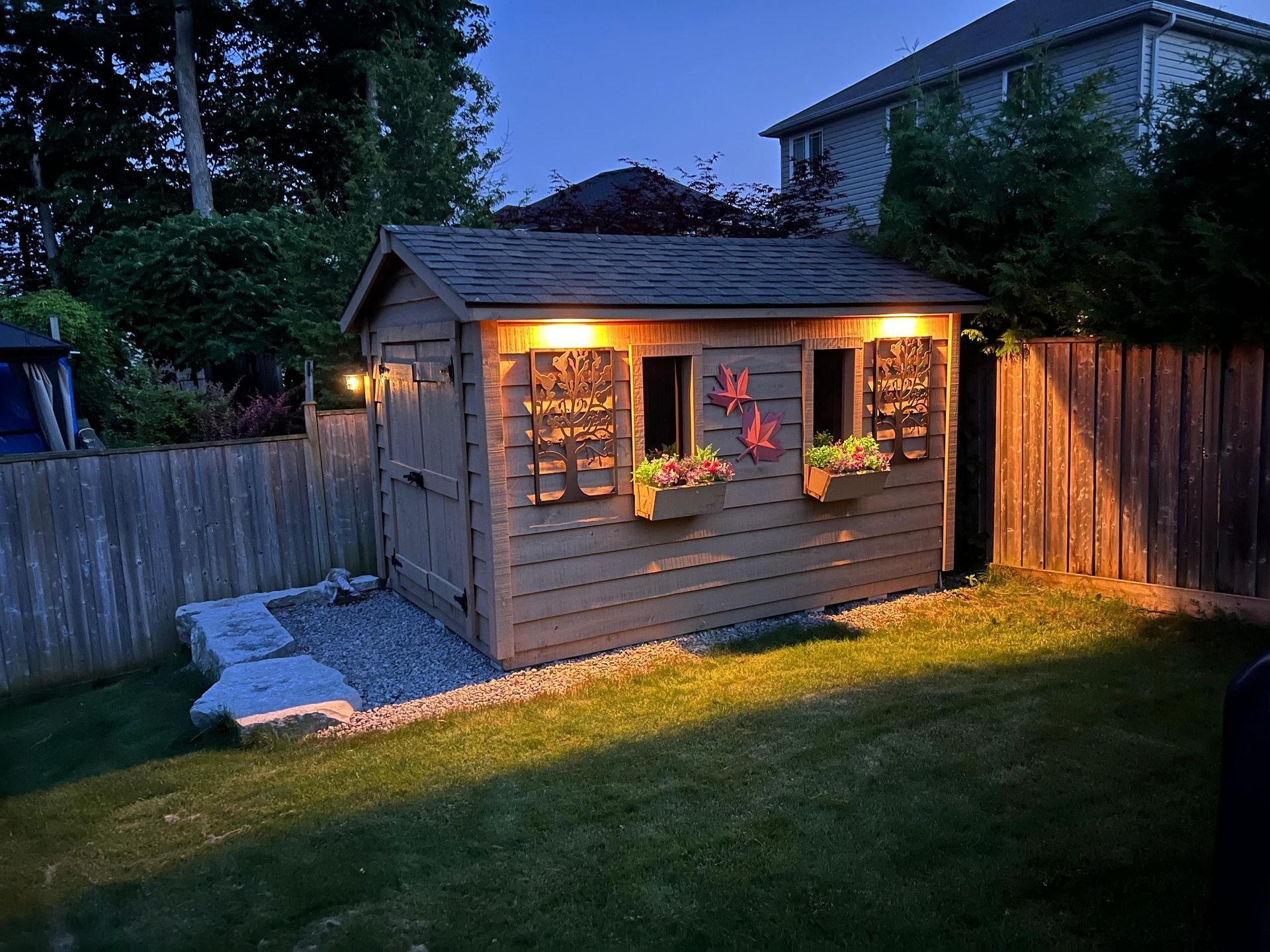 Decorative shed lighting with wall sconces and garden accents