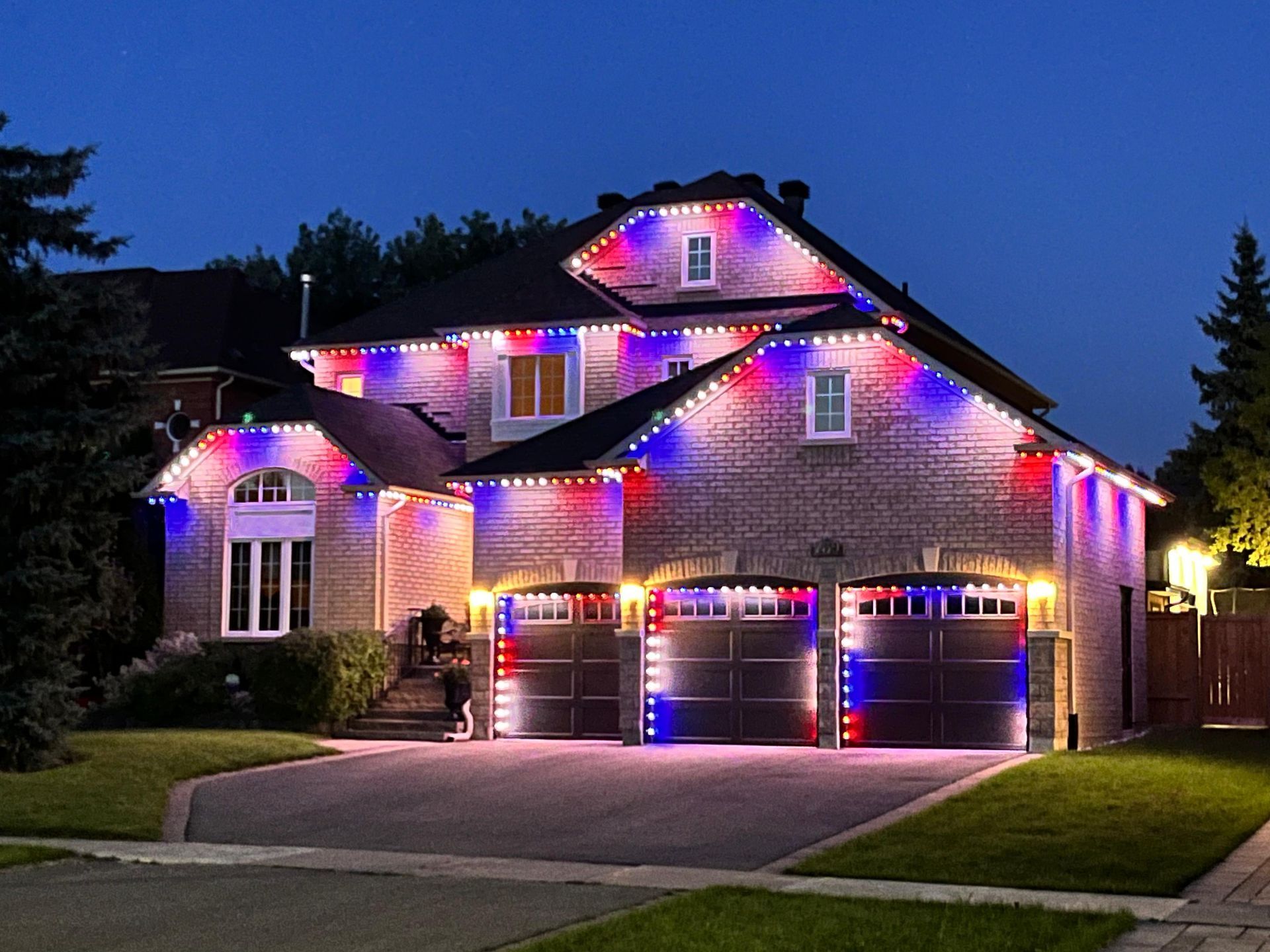 Permanent RGB holiday lights on two-story home for seasonal celebrations