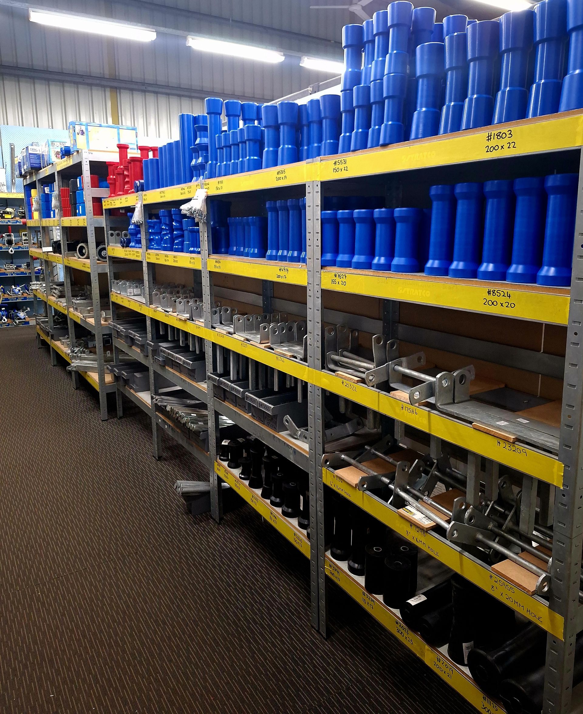 A warehouse filled with shelves filled with blue and yellow items — BTC Parts & Accessories In Pinelands, NT