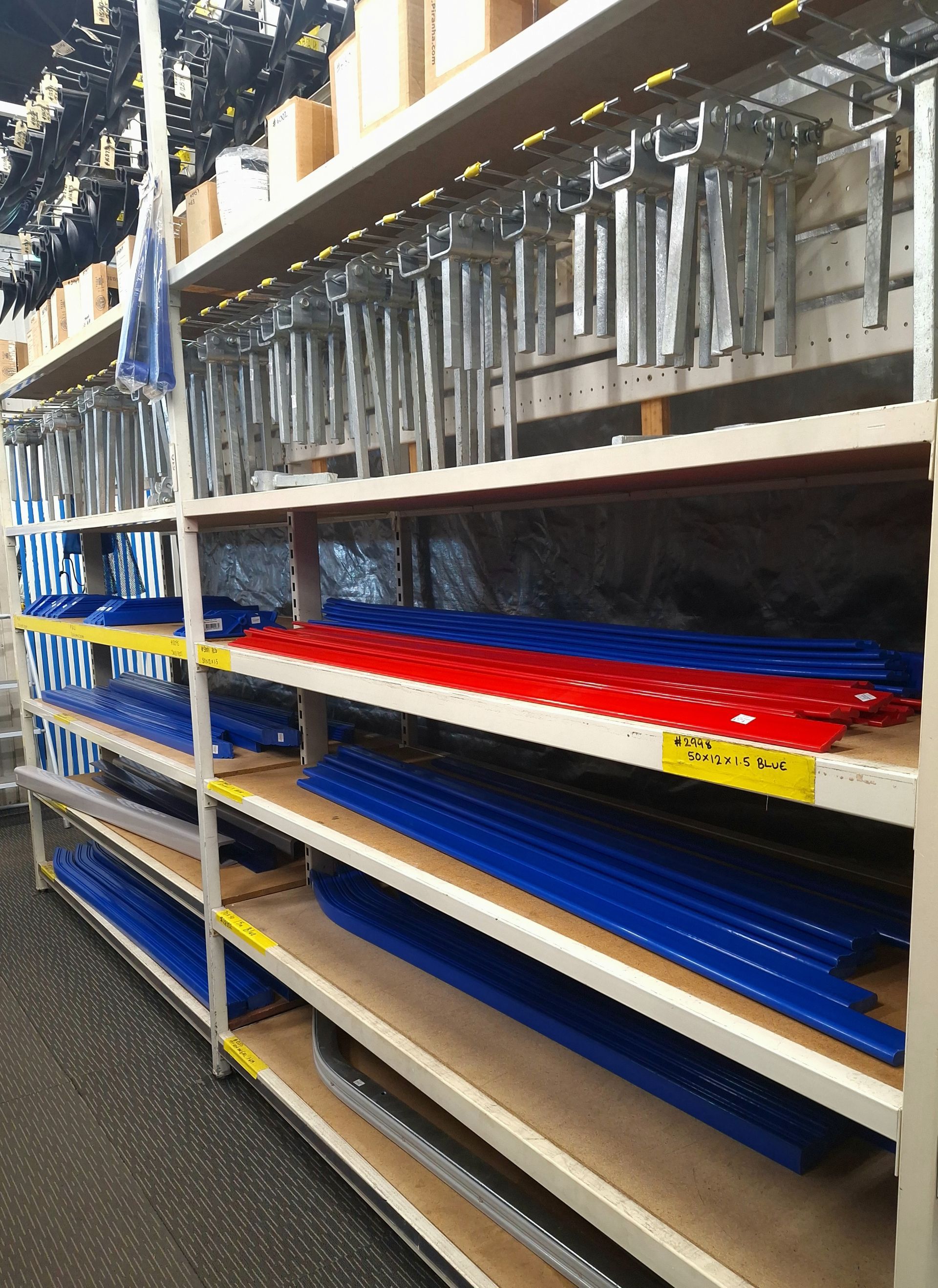 A warehouse filled with shelves filled with blue and red pipes — BTC Parts & Accessories In Pinelands, NT