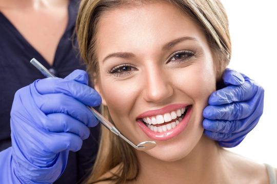 dentista mentre mostra delle protesi dentali