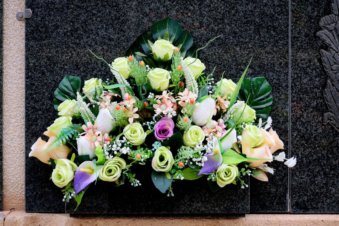 A bouquet of flowers is sitting on a stone wall.