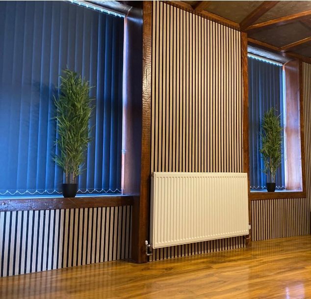 A room with vertical blinds and a white radiator