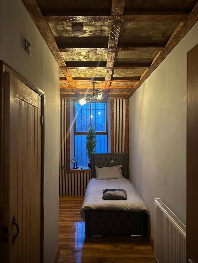 A small bedroom with a single bed and a window.