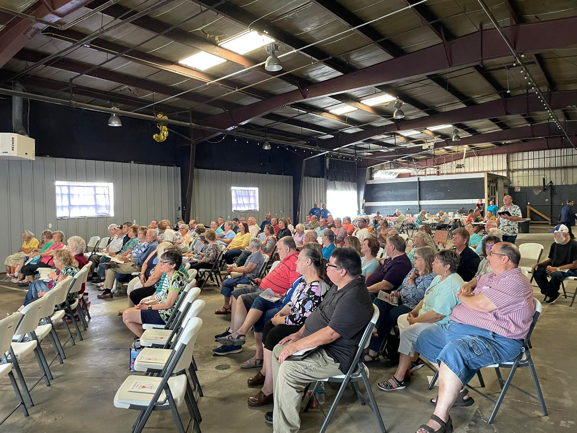Group reading Bibles outdoors; people in chairs, hands clasped in prayer.