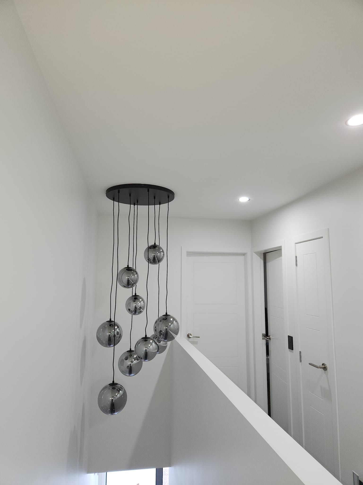 A staircase with a chandelier hanging from the ceiling.