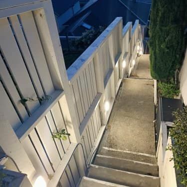 A set of stairs leading up to a building with a wooden railing.