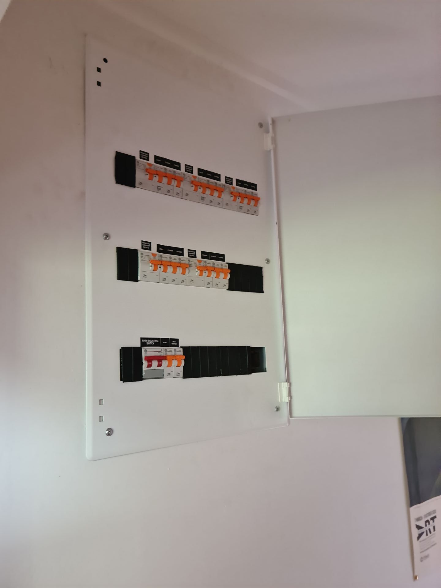 A person is working on an electrical box with a screwdriver.