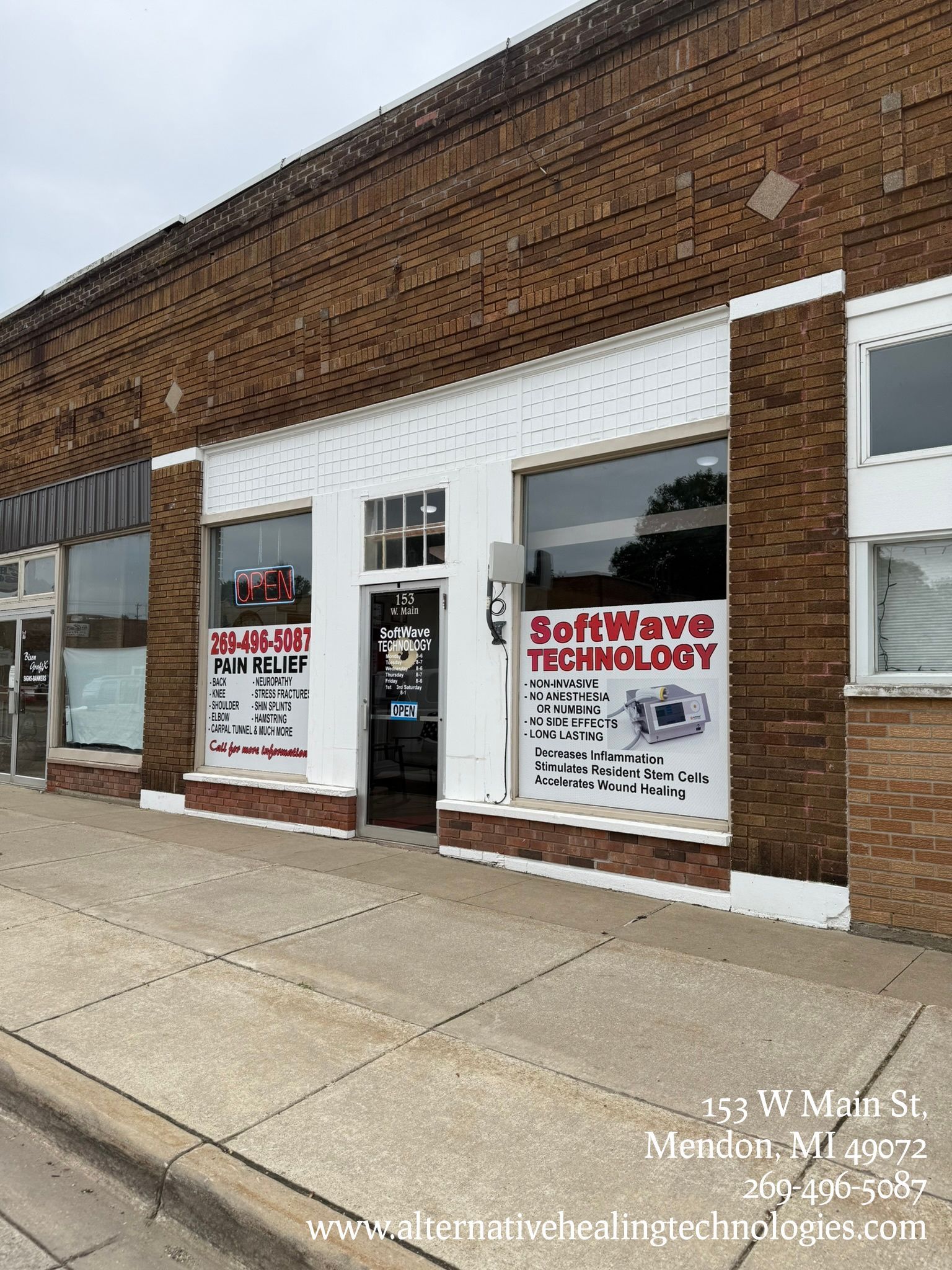 Exterior of "SoftWave Technology" storefront, brown brick building, glass windows with signage, sidewalk in front.