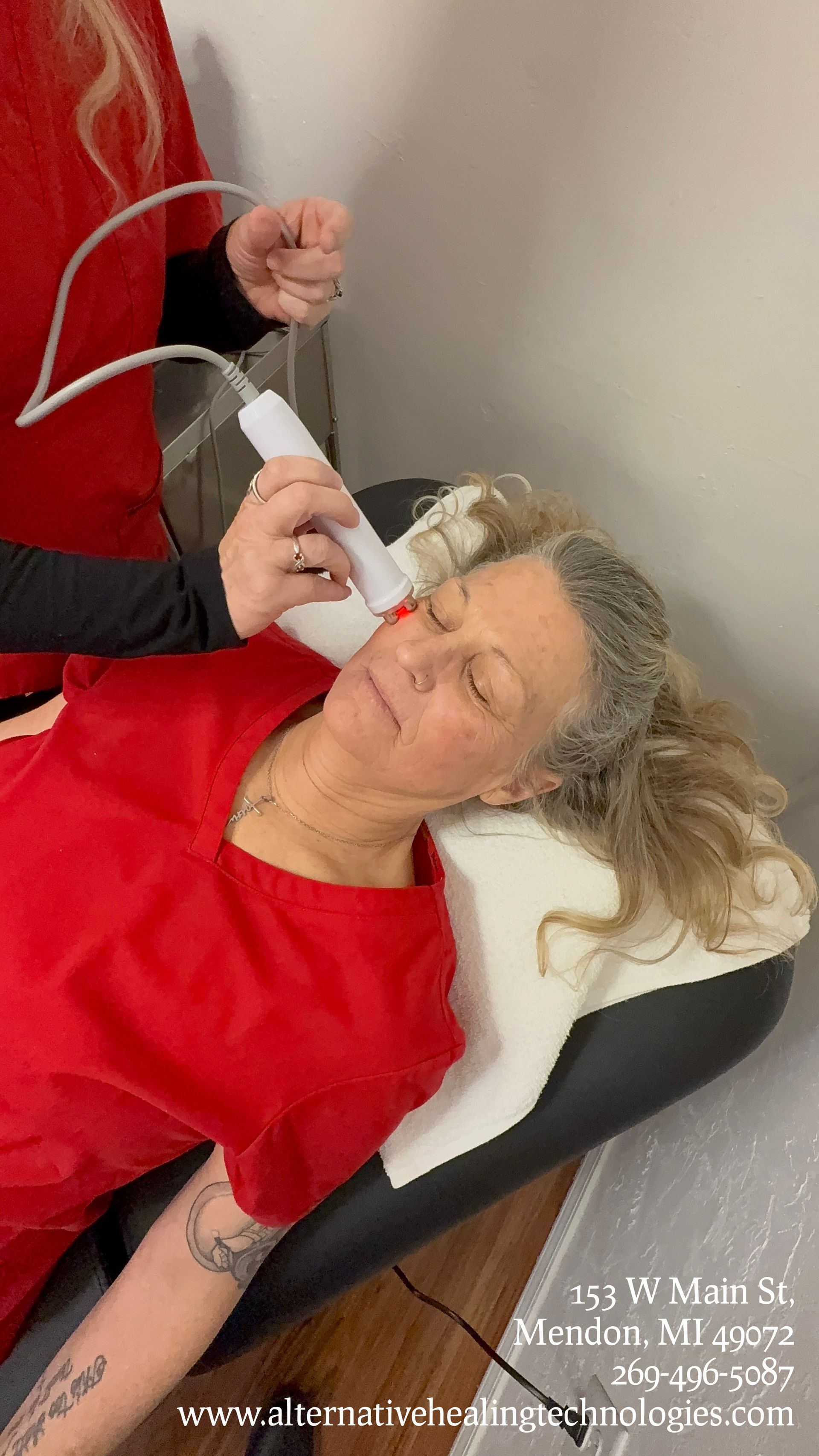 Cozy therapy room: black armchair, white cabinet, medical charts, and a metal shelf.