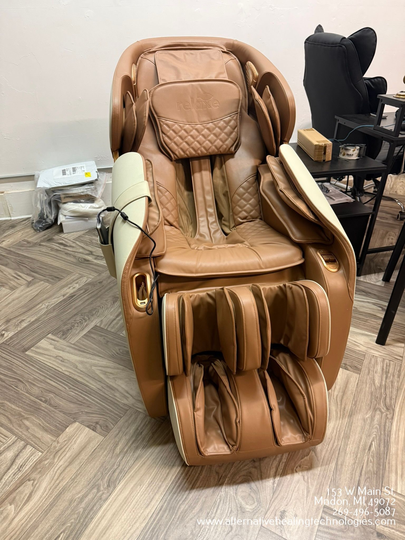 Brown and cream massage chair in a room with wood-like flooring.