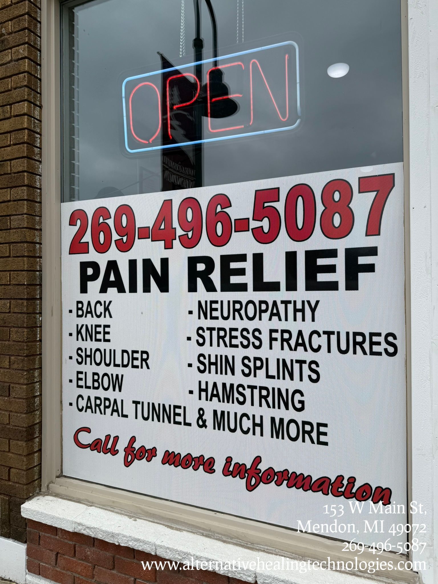 A store window sign advertising pain relief services, with a phone number and list of treatable conditions.