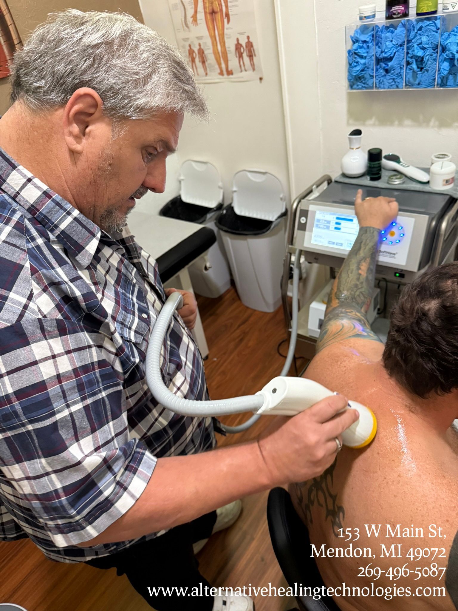 A practitioner uses an ultrasound therapy device on a patient's shoulder in a clinical office.