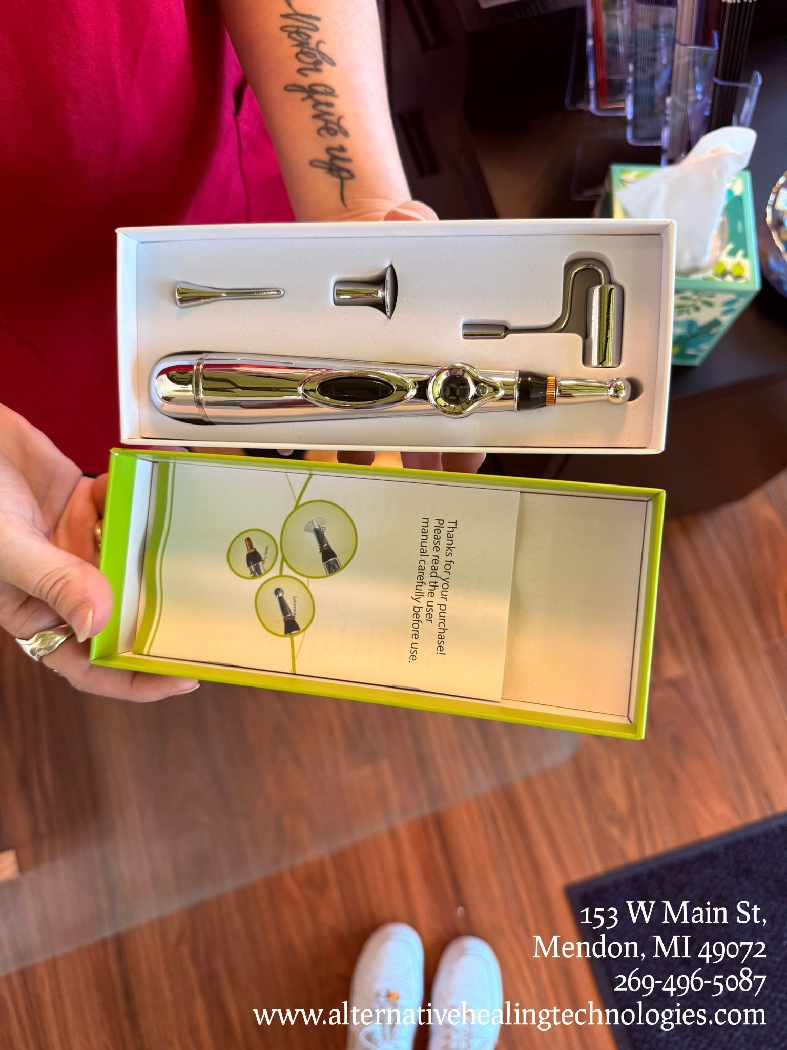 Black wrought iron baker's rack with items on shelves and a trash can, desk, and cabinet in the corner.