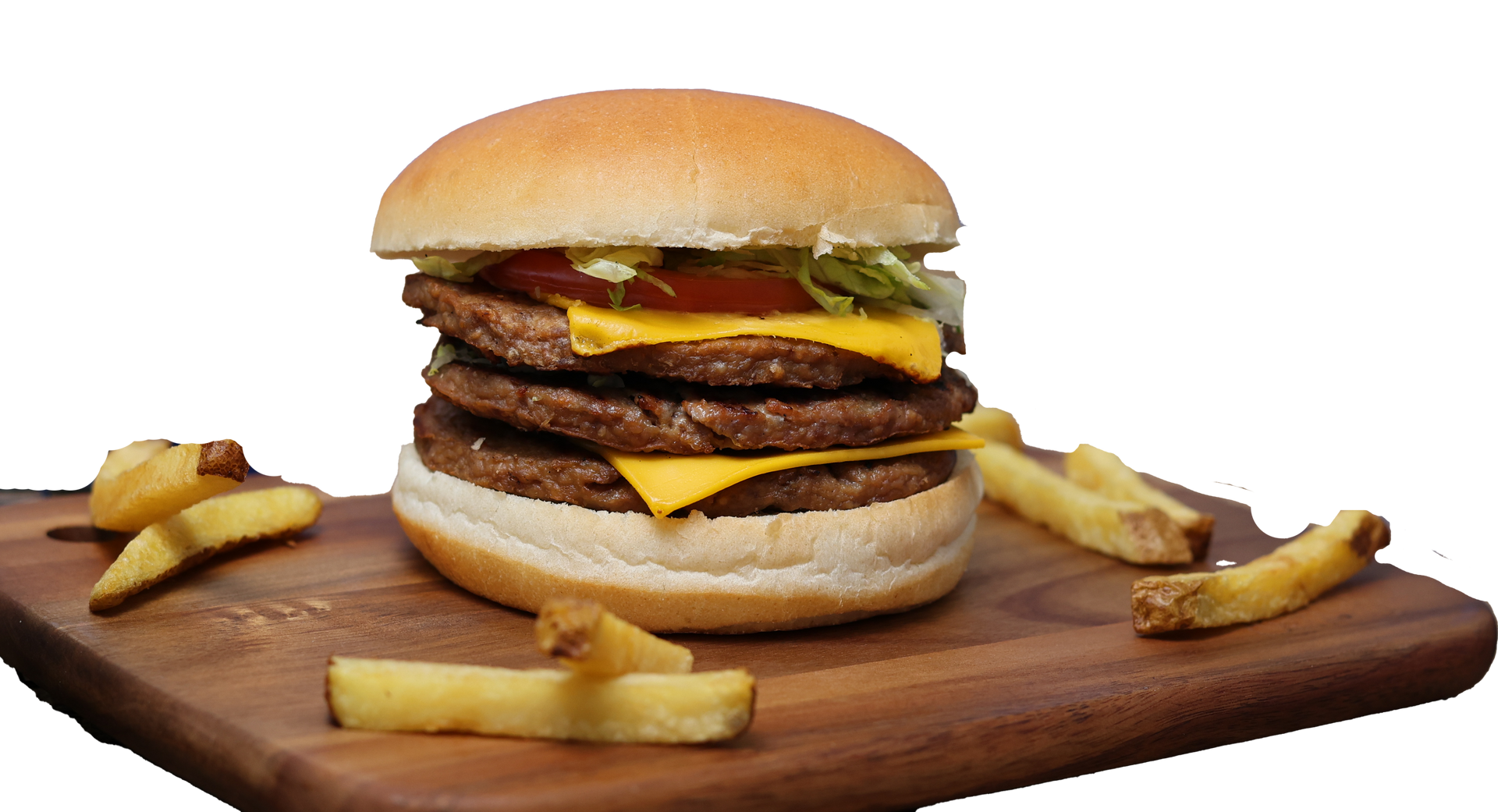 Triple cheeseburger with fries on a wooden board.