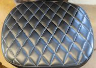 Black quilted cushioned seat with a diamond pattern