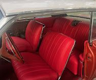 Red vintage car interior with bright red bench seats and matching upholstery