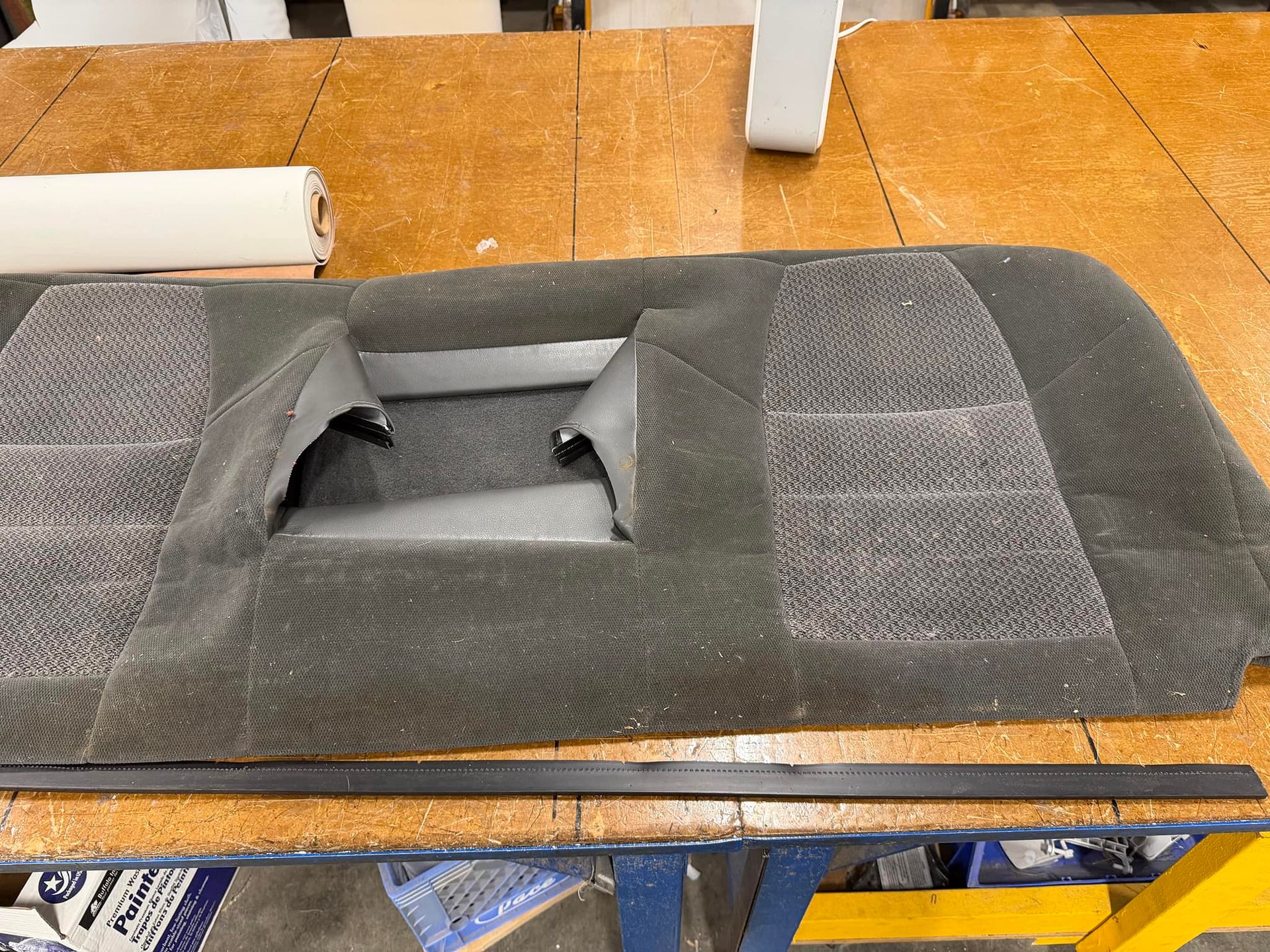 Gray pet car seat booster on a wooden table with a central cutout opening