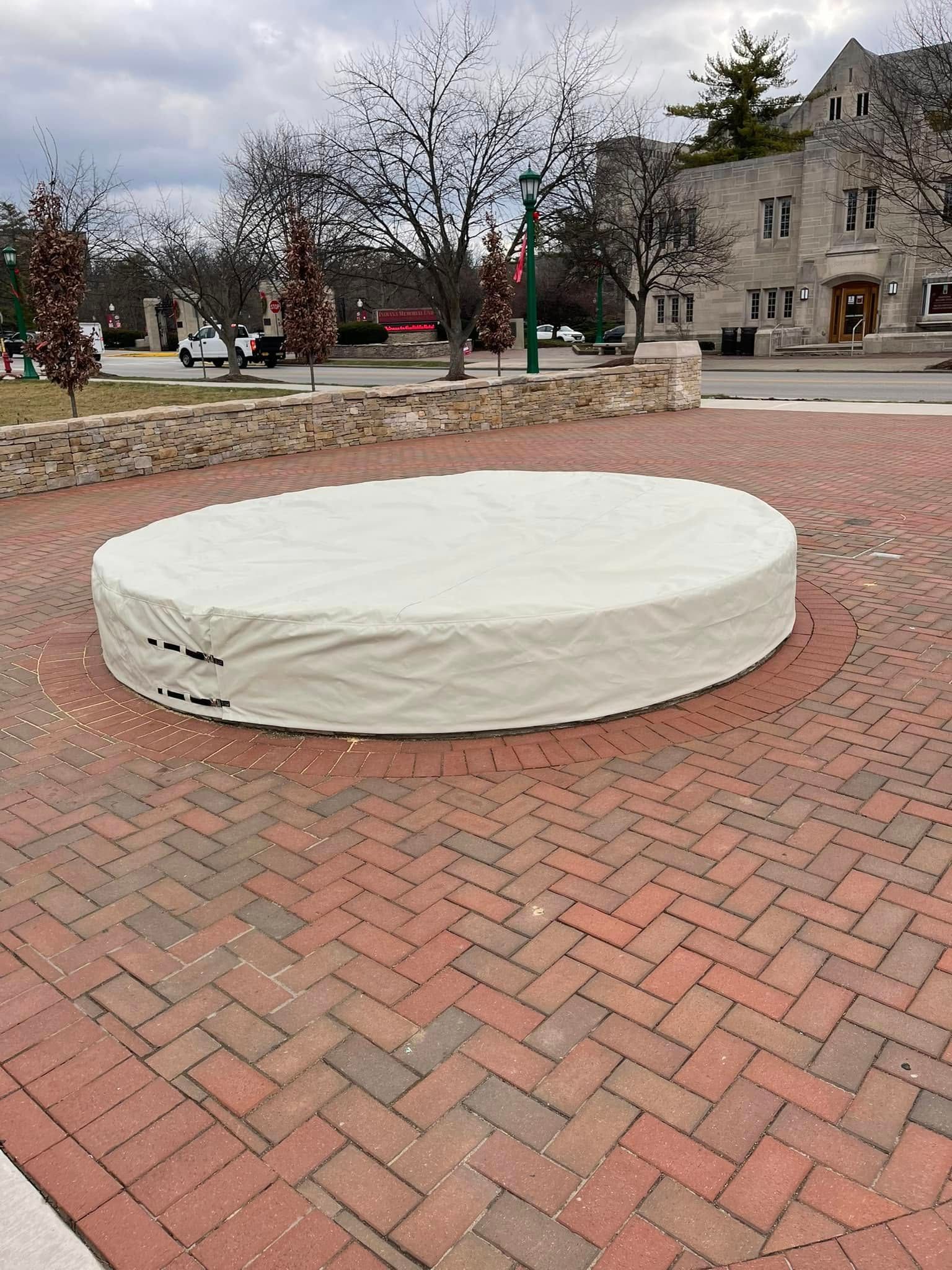 Covered round platform on a brick plaza in a park setting