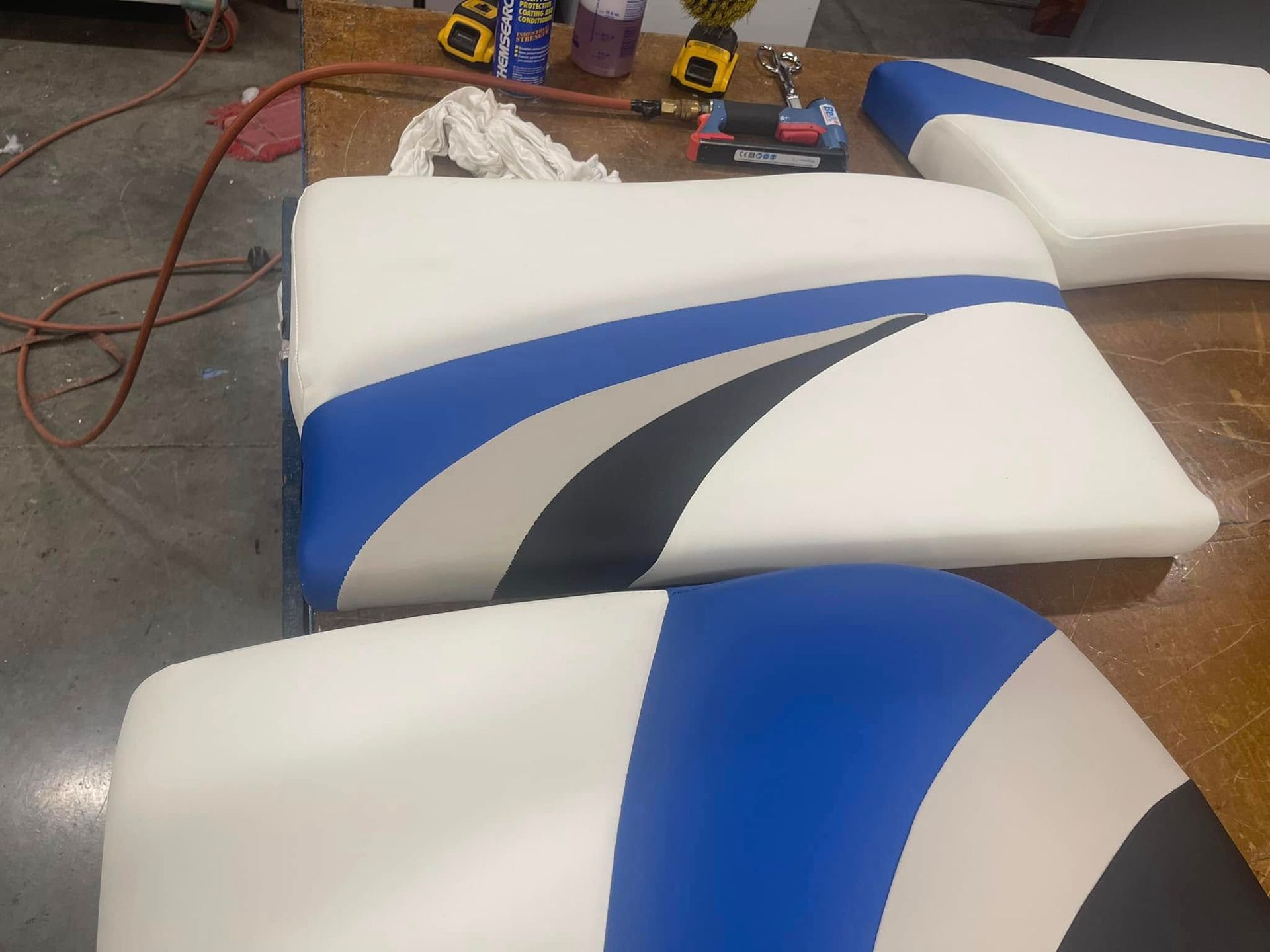 White upholstered cushions with blue and gray curved stripes in a workshop setting