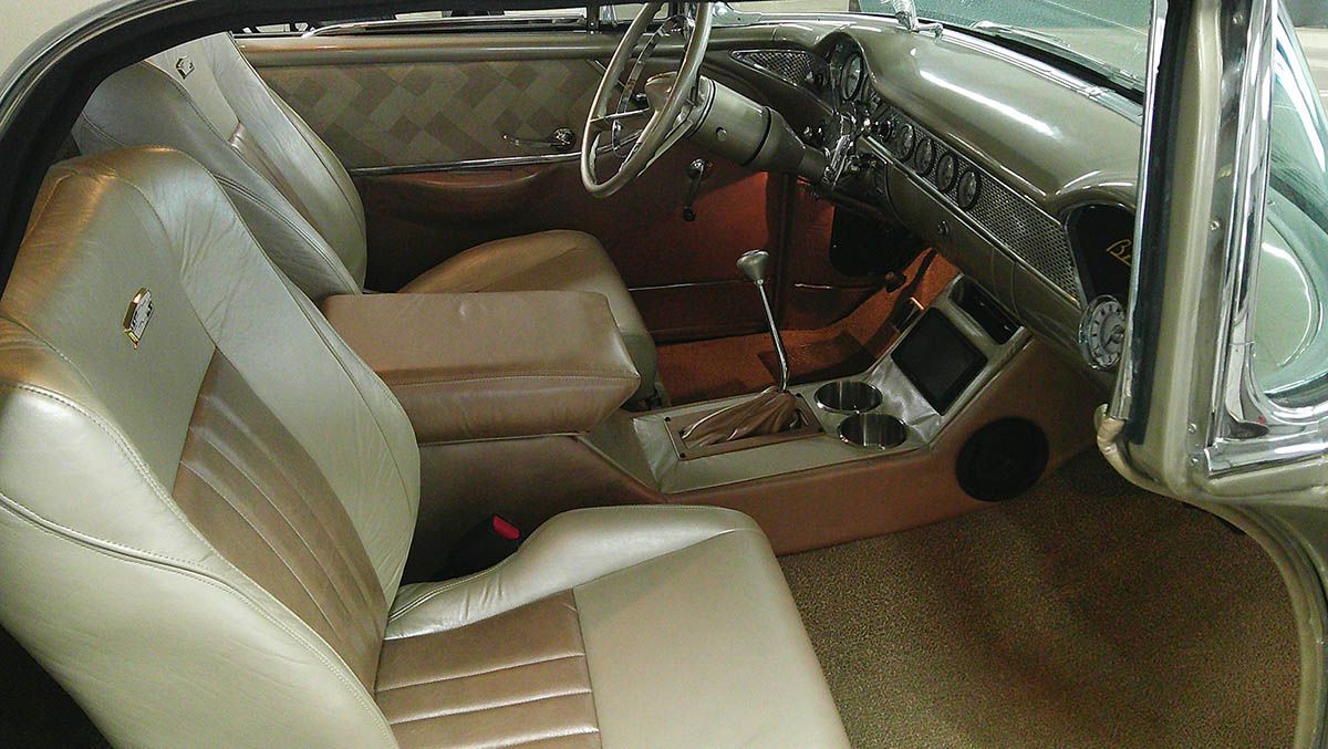 Tan leather car back seat with ribbed upholstery and armrest, seen through the rear window at sunset