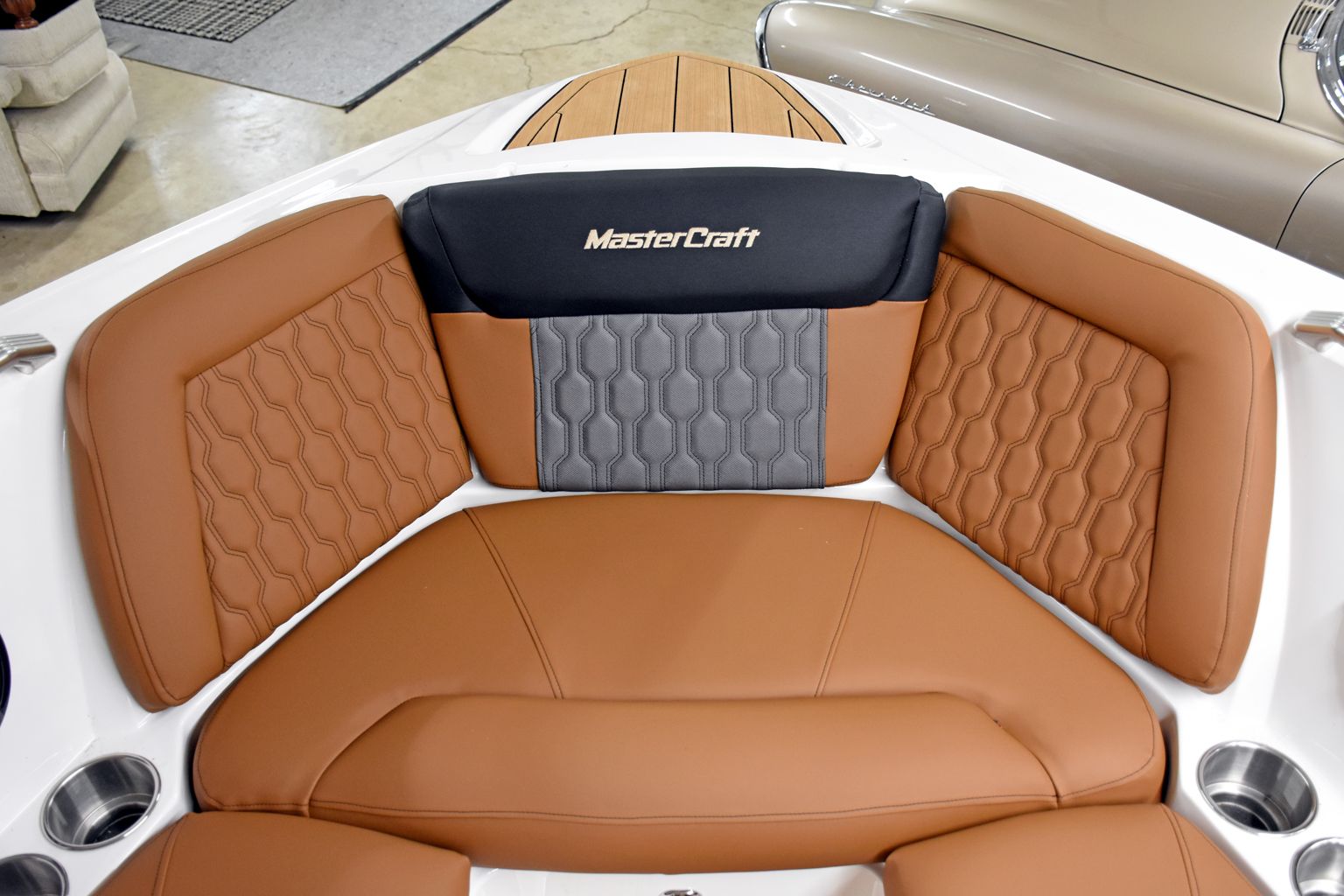 Empty white-and-tan boat deck with cushioned seating on open water