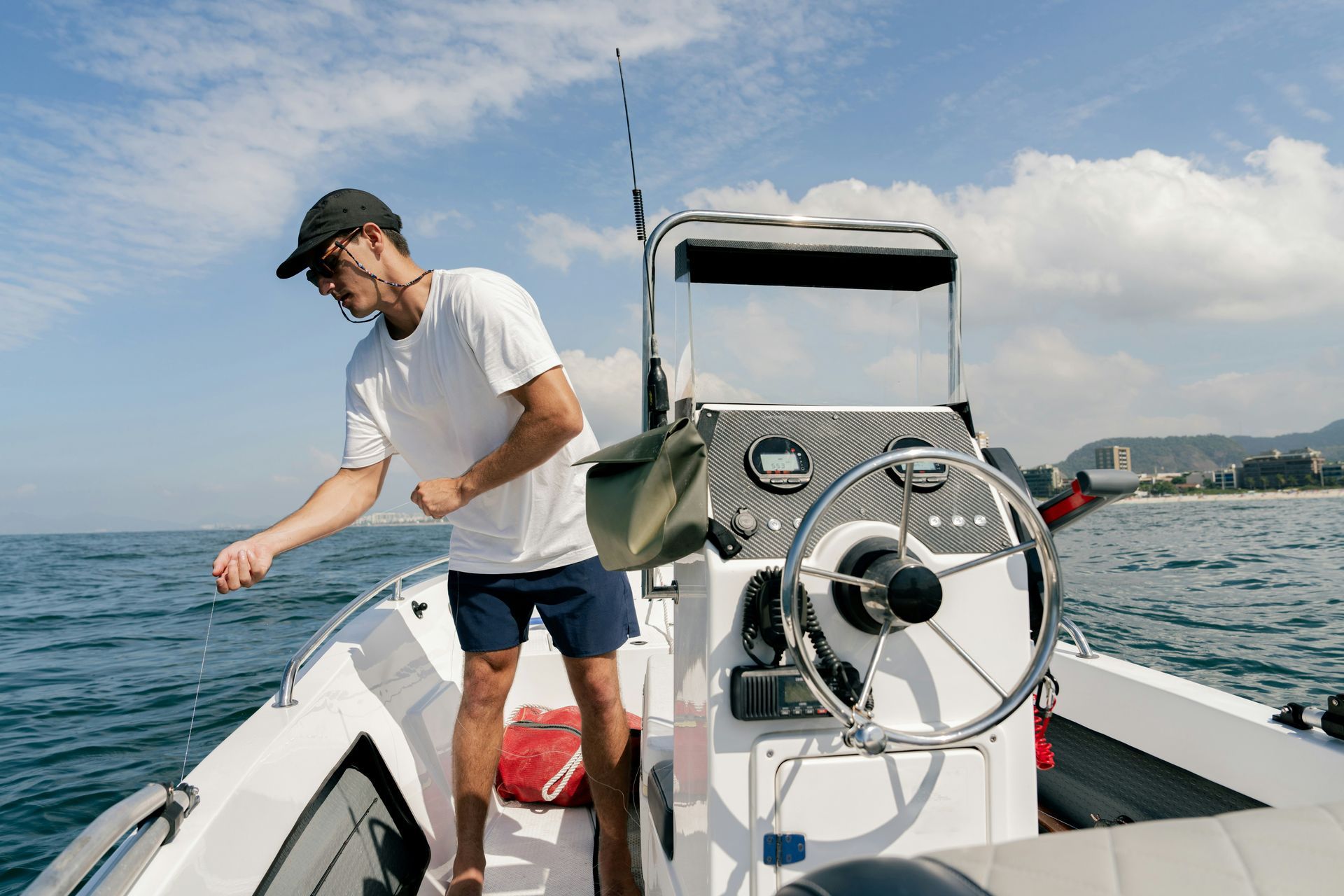 A man is standing on a boat in the ocean.