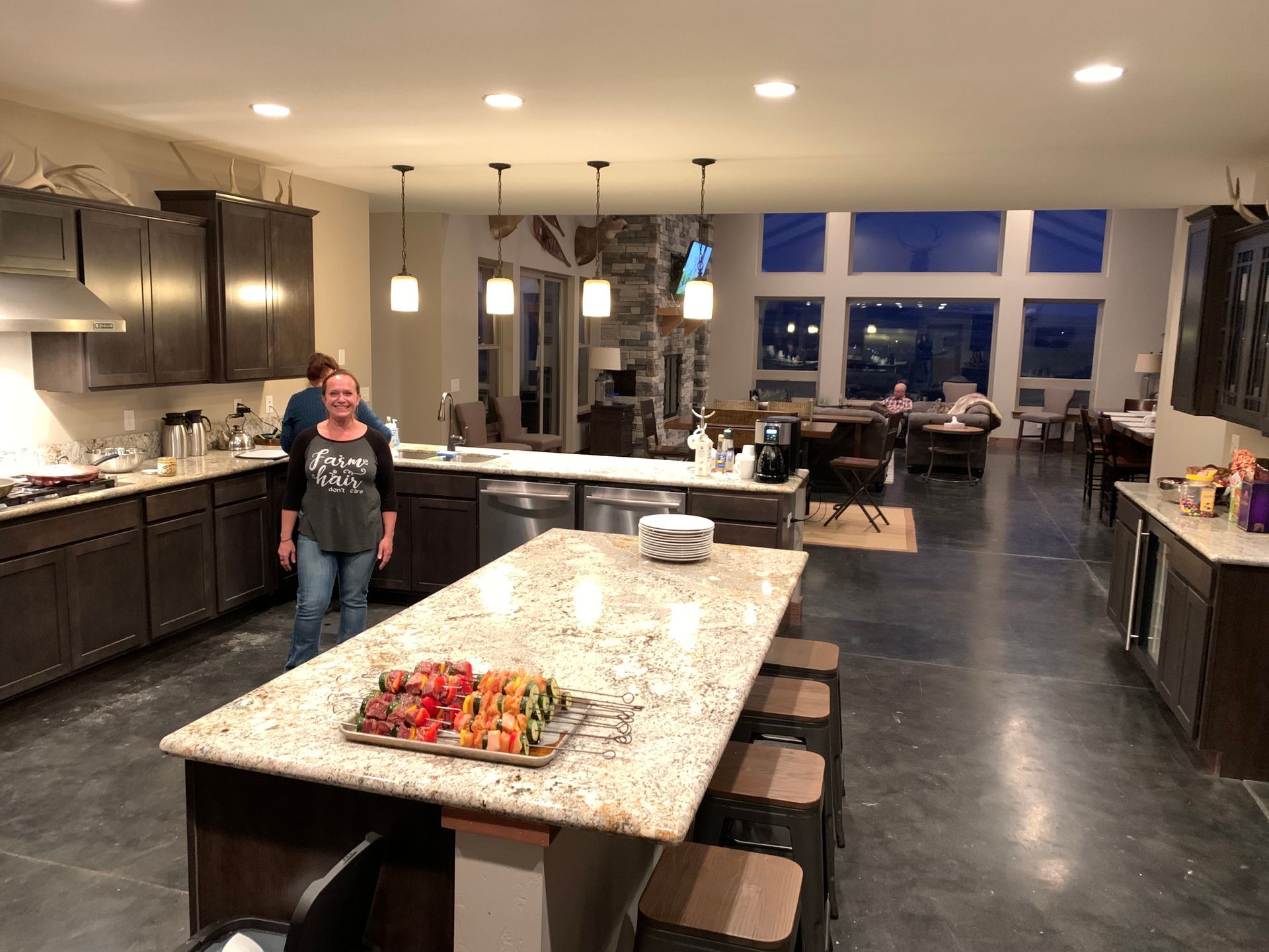 A woman is standing in a kitchen next to a large island.