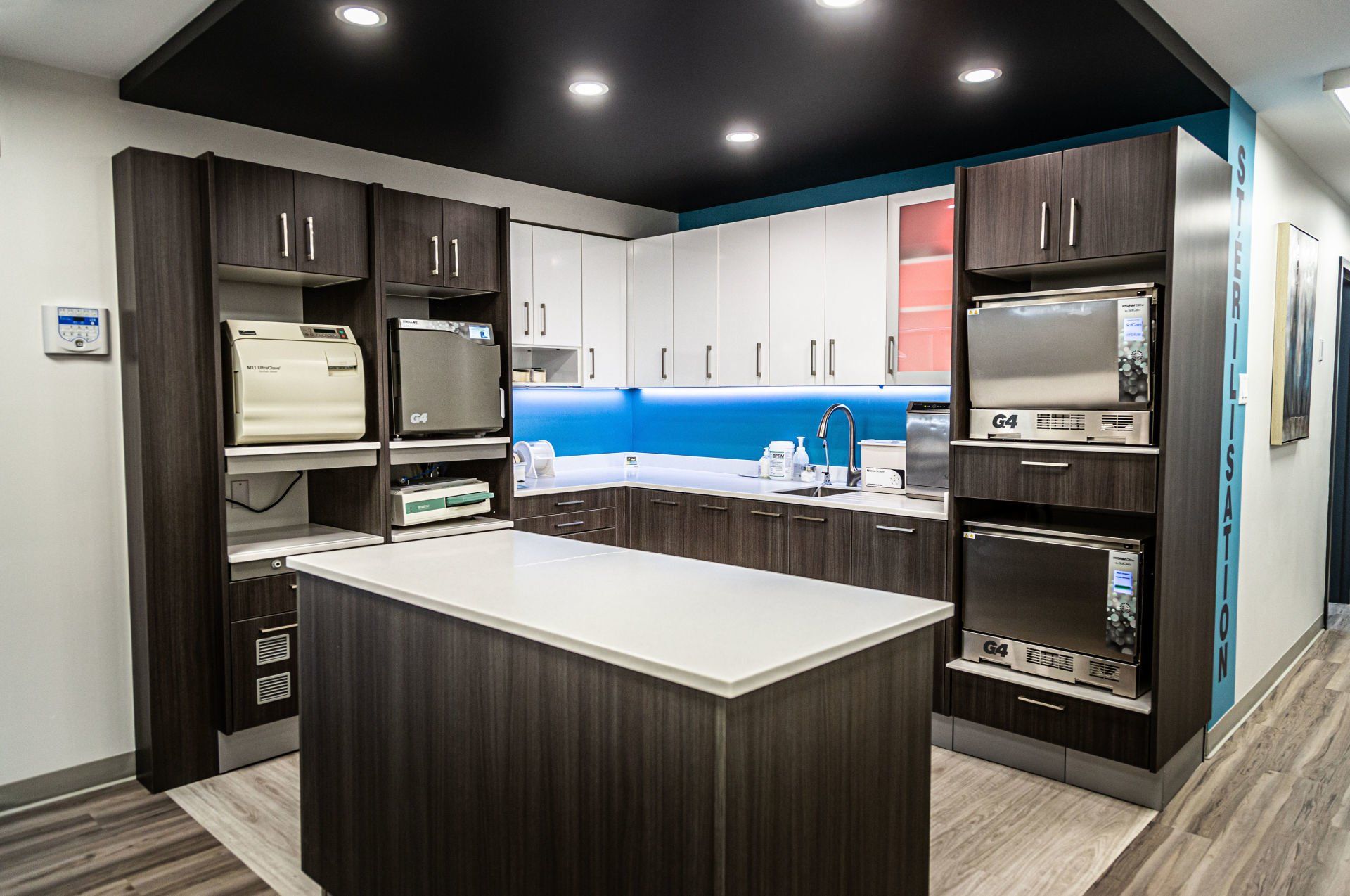 station de stérilisation avec armoires foncées et comptoir blanc