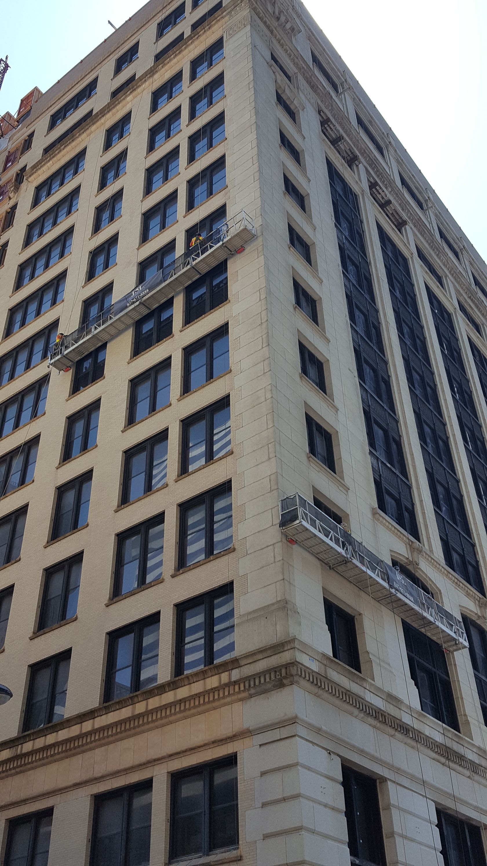 A tall building with a lot of windows and a blue sky in the background.