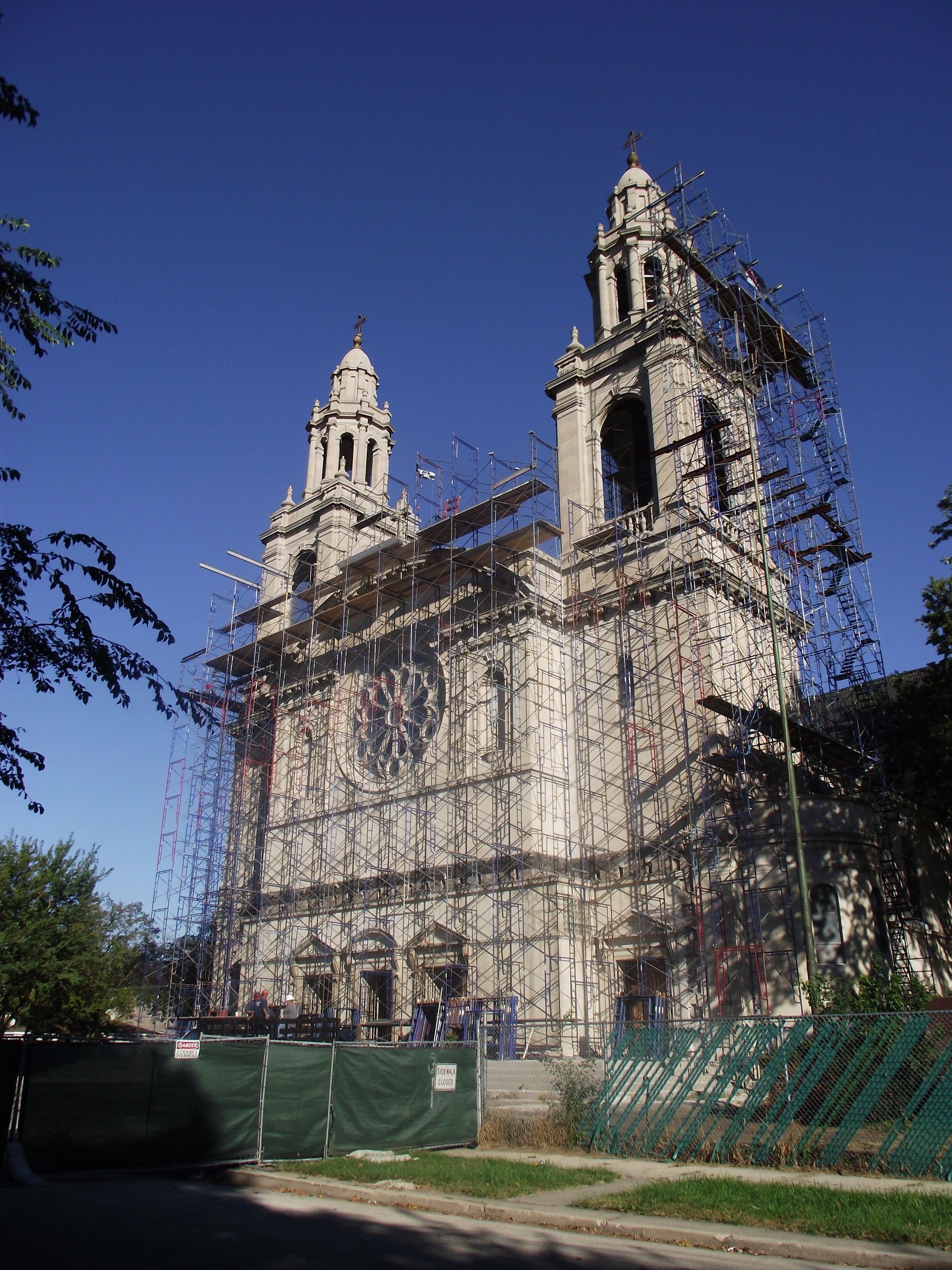 A large building with scaffolding around it and a blue sky in the background