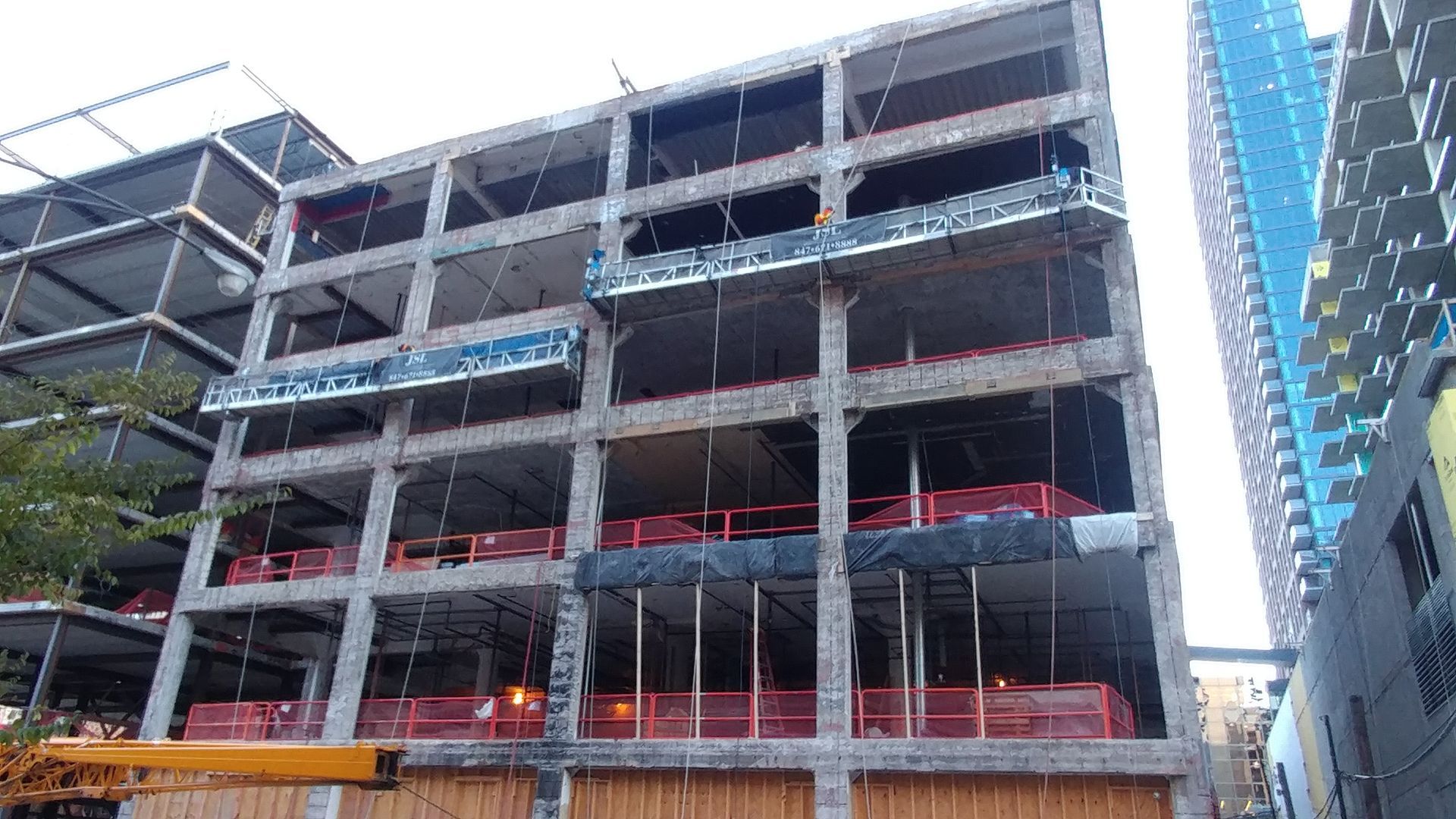 A large building under construction with a crane in front of it.