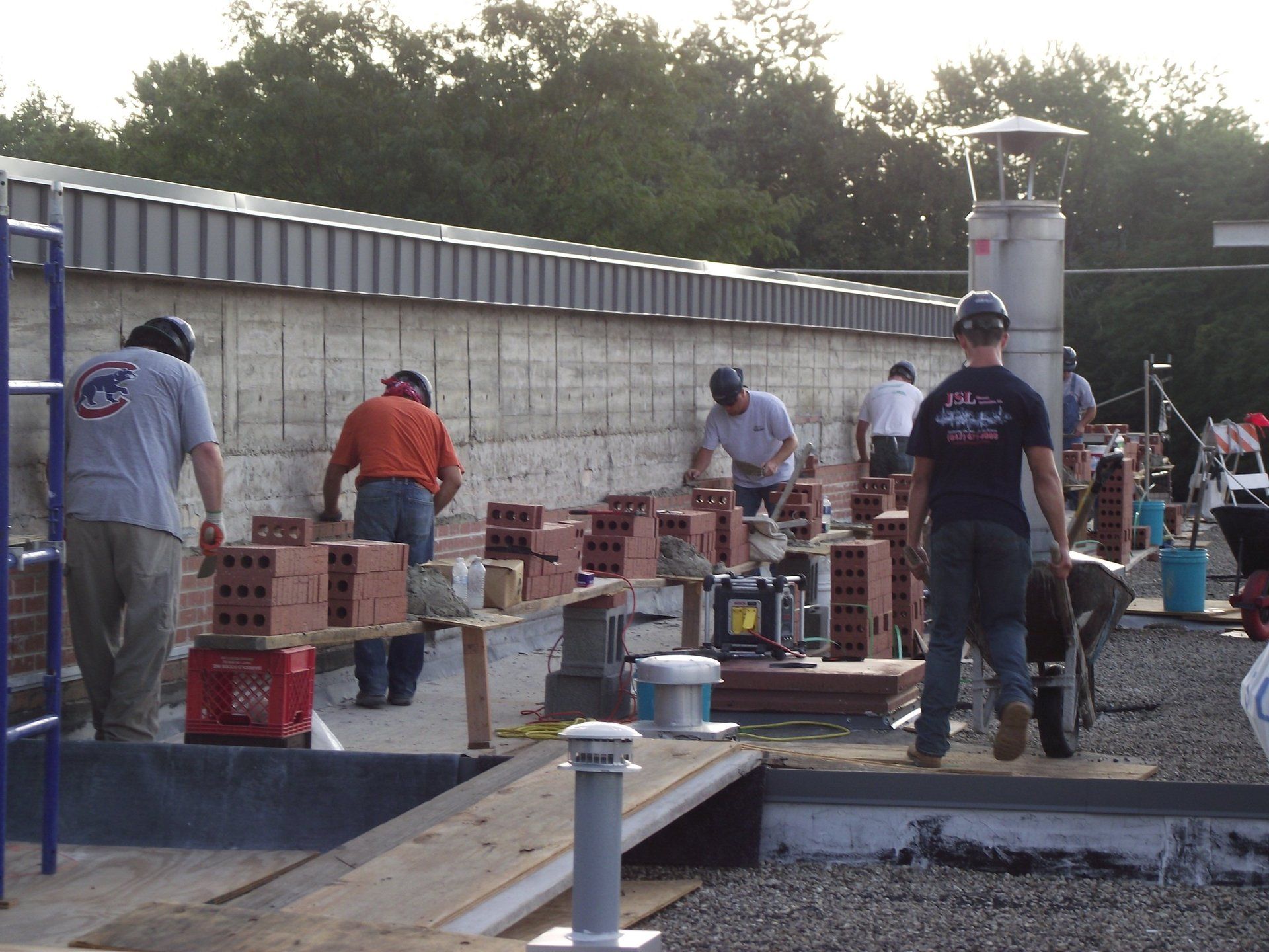 A group of construction workers are working on a brick wall