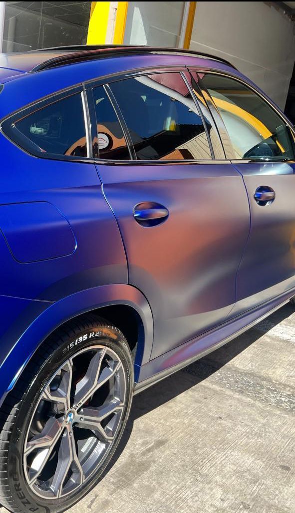 Un coche azul está estacionado al costado de la carretera.